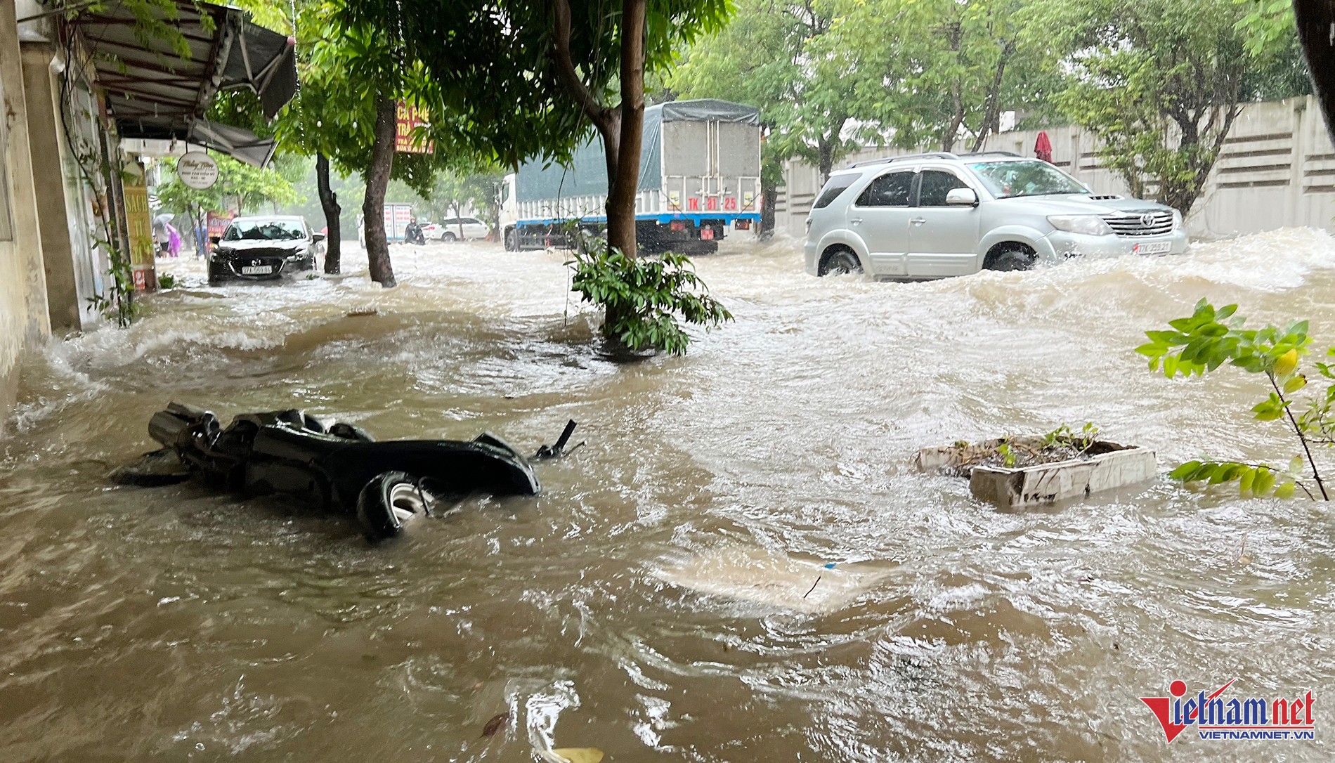 Ô tô và xe máy di chuyển trong điều kiện ngập sâu tại TP Vinh